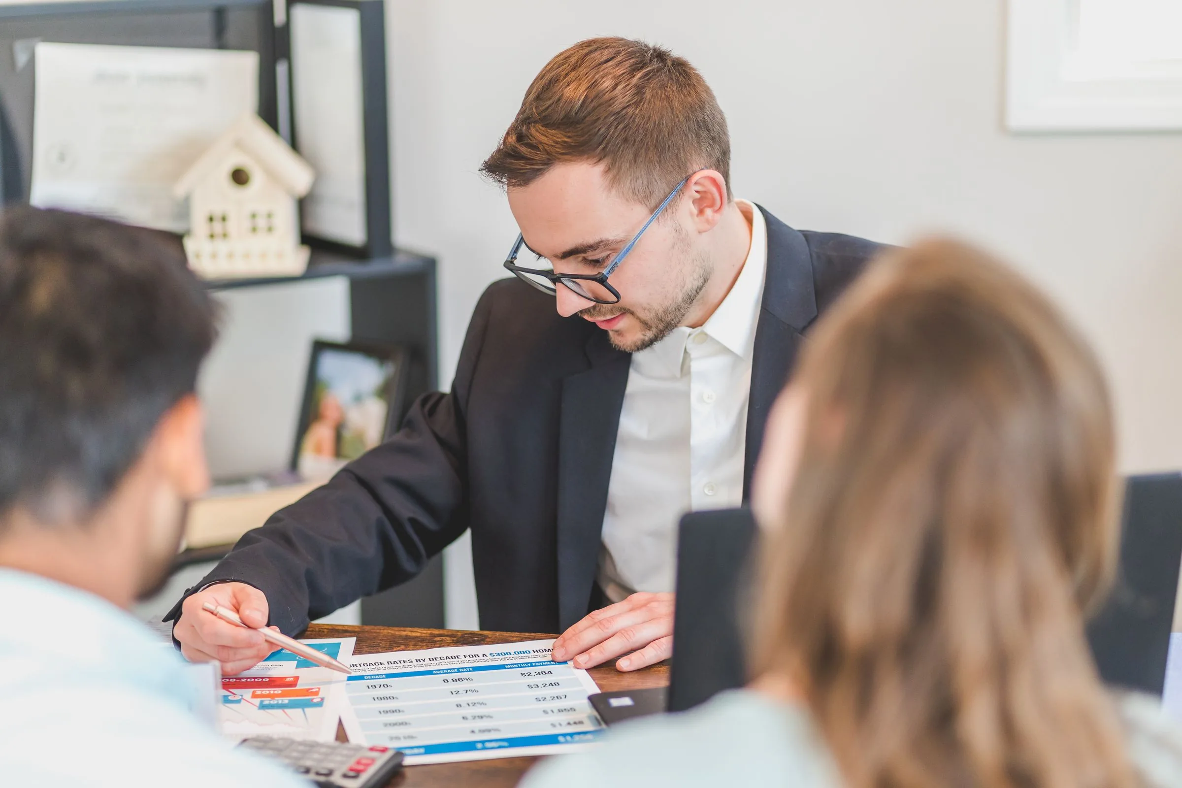 An adviser discussing printed charts with two clients