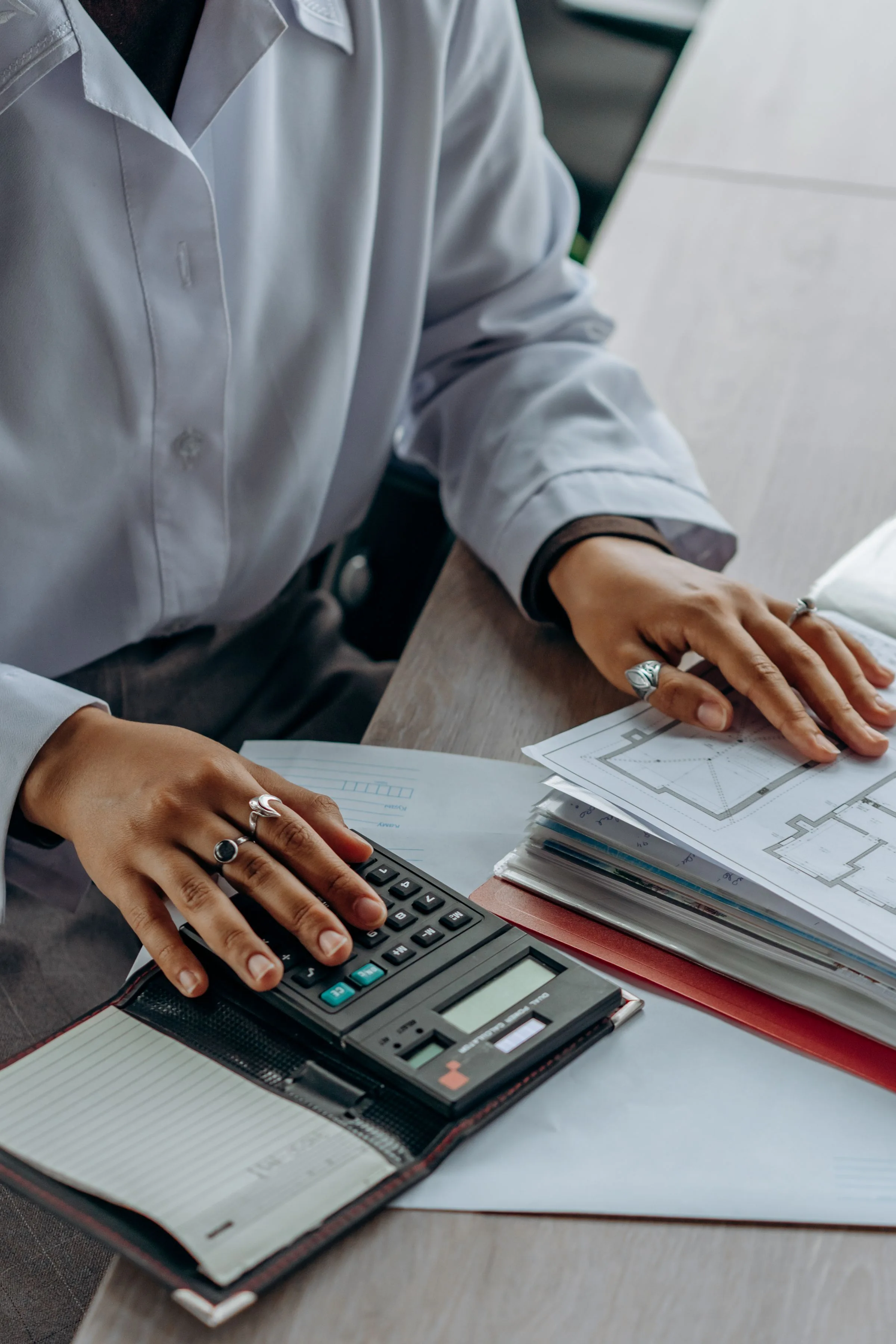Close view of an accountant checking paperwork with a calculator
