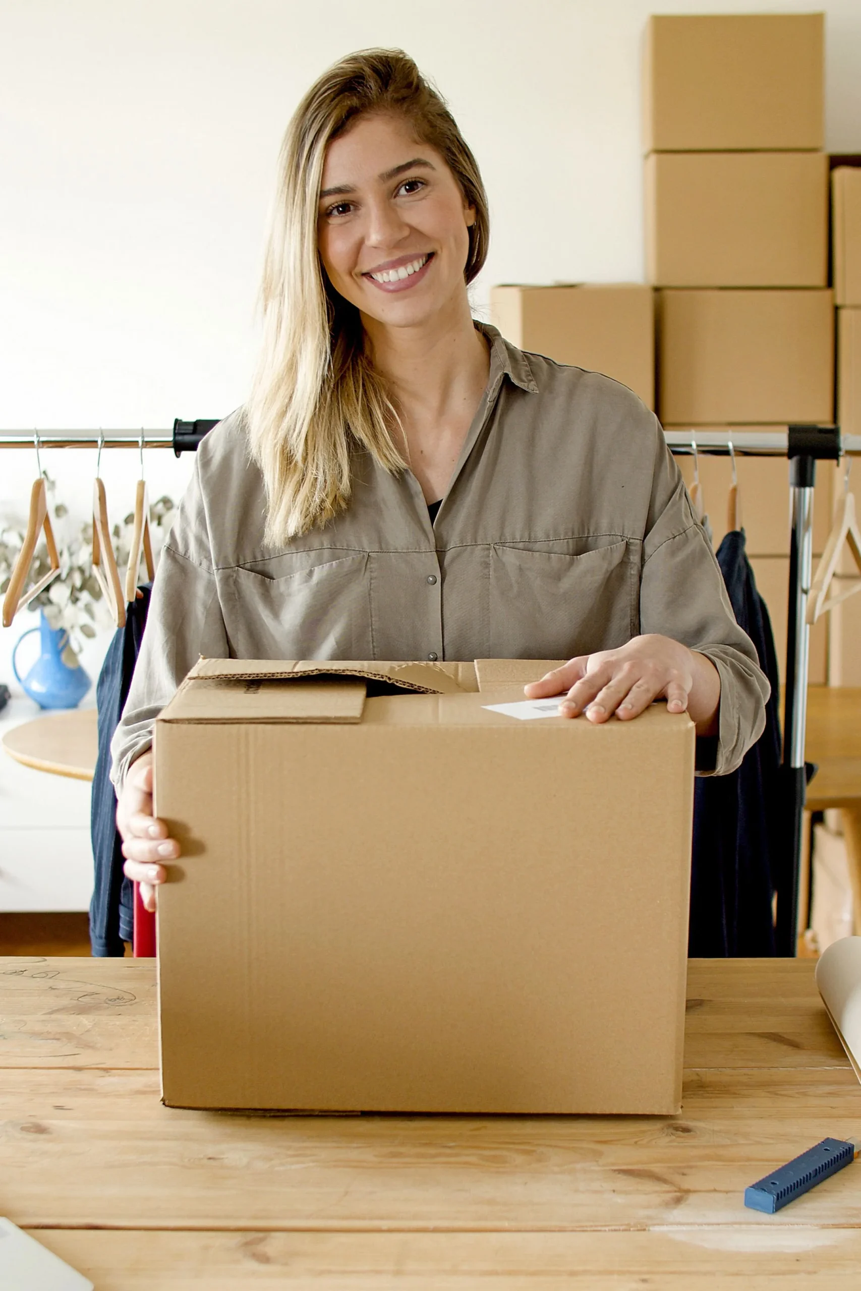 A small business owner holding a parcel in her clothing shop