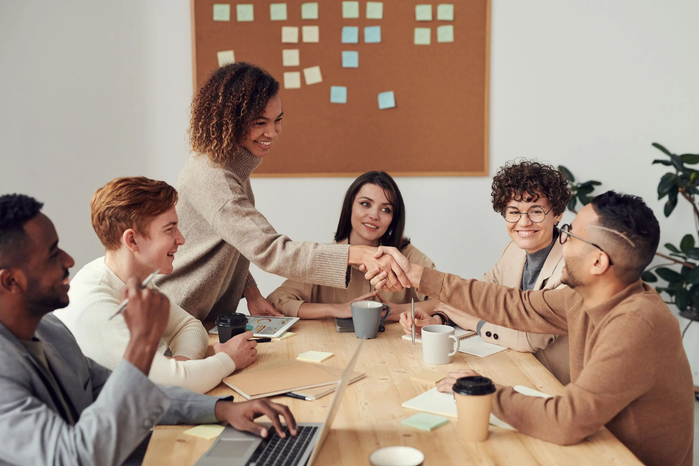 Colleagues greeting one another across a meeting table
